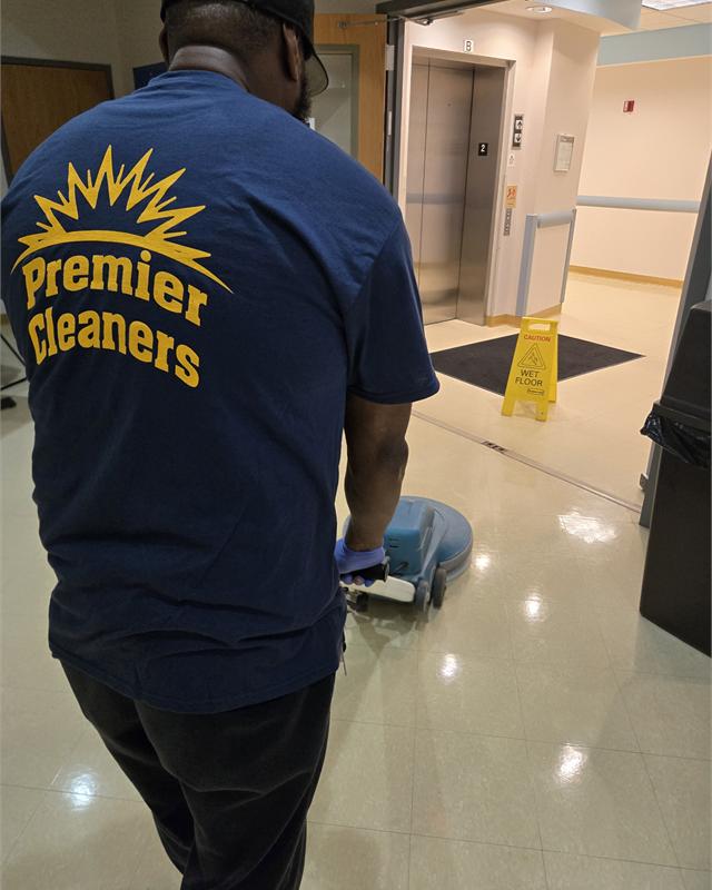 Commercial floor care work with floor equipment and a Premier shirt visible.